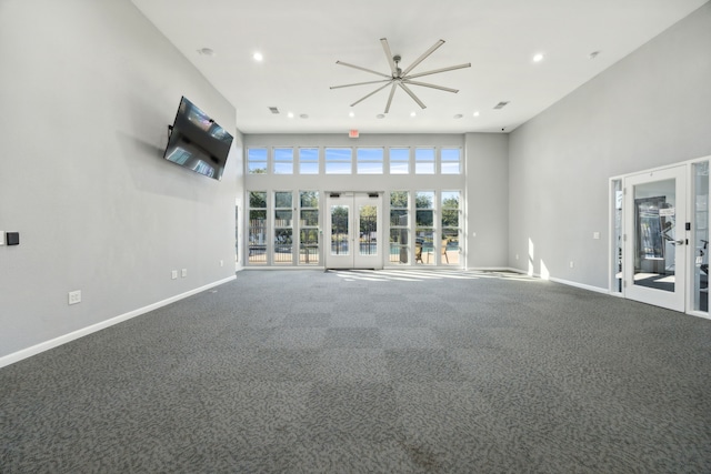 unfurnished living room with french doors, carpet flooring, and a high ceiling