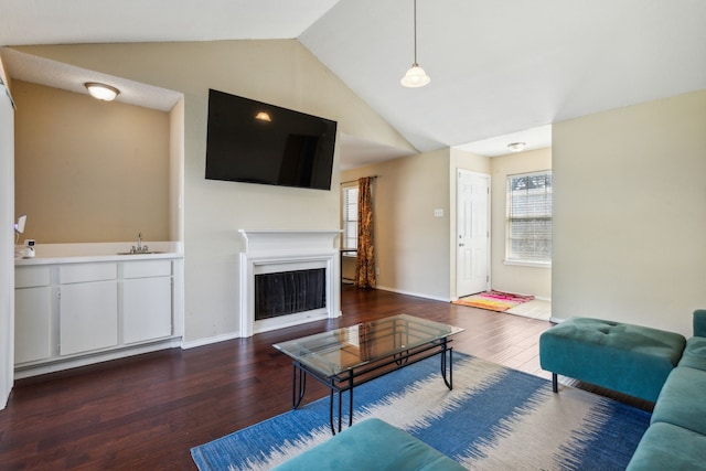 living room featuring dark hardwood / wood-style flooring, sink, and vaulted ceiling