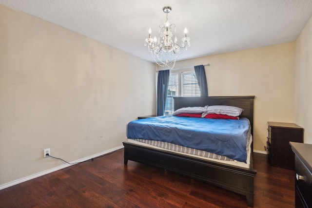 bedroom with dark wood-type flooring, a textured ceiling, and a notable chandelier