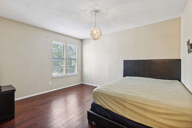 bedroom featuring dark hardwood / wood-style floors and an inviting chandelier