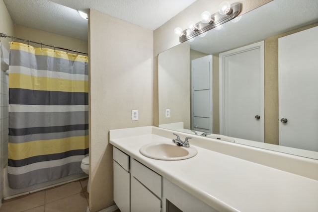 bathroom featuring vanity, tile patterned floors, a textured ceiling, and toilet