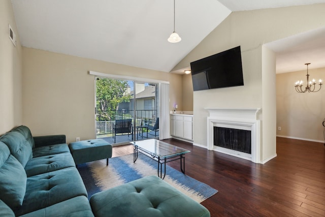 living room featuring hardwood / wood-style floors, lofted ceiling, and an inviting chandelier