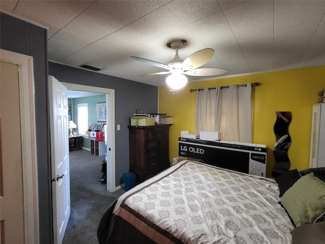 bedroom featuring ceiling fan and dark carpet