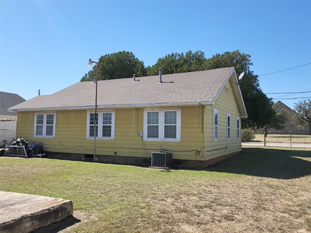 rear view of house with a lawn and central air condition unit