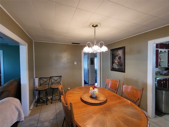 dining room featuring tile patterned floors and a chandelier