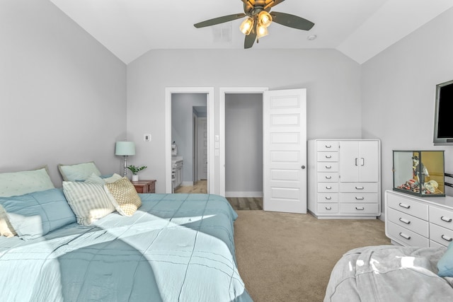 carpeted bedroom featuring vaulted ceiling, ensuite bathroom, and ceiling fan