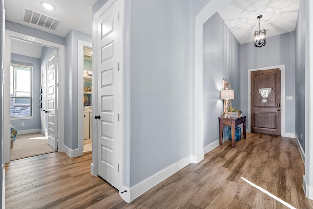 entrance foyer with wood-type flooring and an inviting chandelier