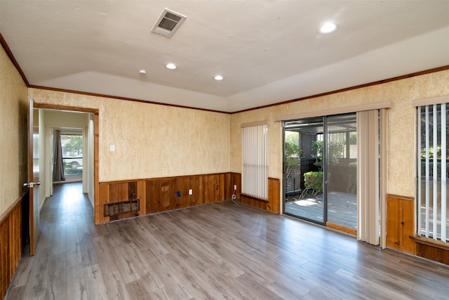 spare room with plenty of natural light, light wood-type flooring, and vaulted ceiling