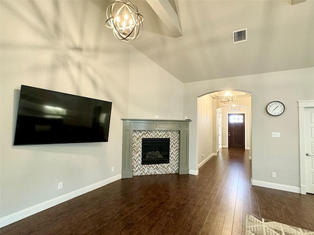 unfurnished living room featuring lofted ceiling, dark hardwood / wood-style flooring, and a tile fireplace