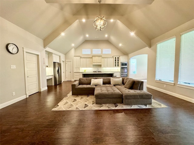 living room with sink, vaulted ceiling, a healthy amount of sunlight, and dark hardwood / wood-style flooring