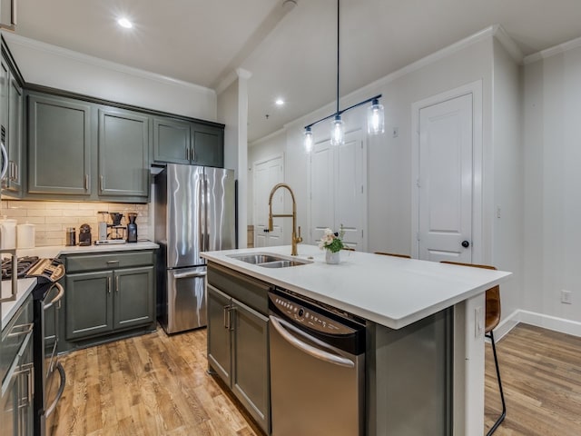 kitchen featuring light hardwood / wood-style floors, stainless steel appliances, an island with sink, and hanging light fixtures