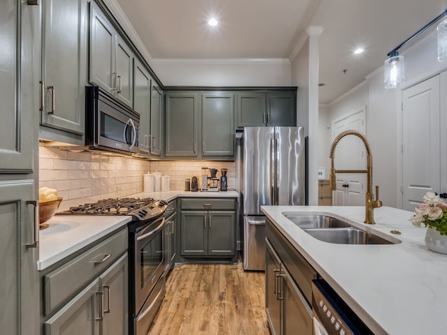 kitchen featuring sink, backsplash, stainless steel appliances, crown molding, and light hardwood / wood-style flooring