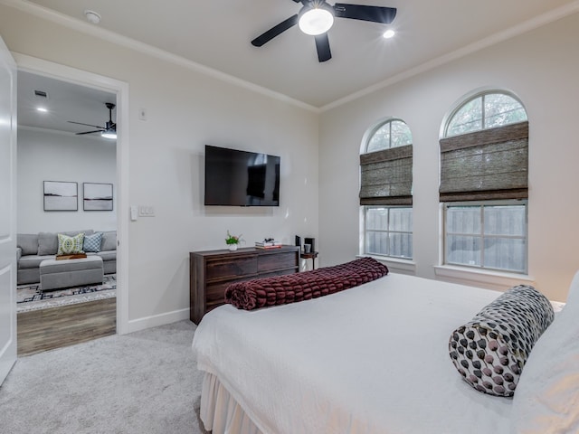 bedroom featuring ornamental molding, light colored carpet, and ceiling fan