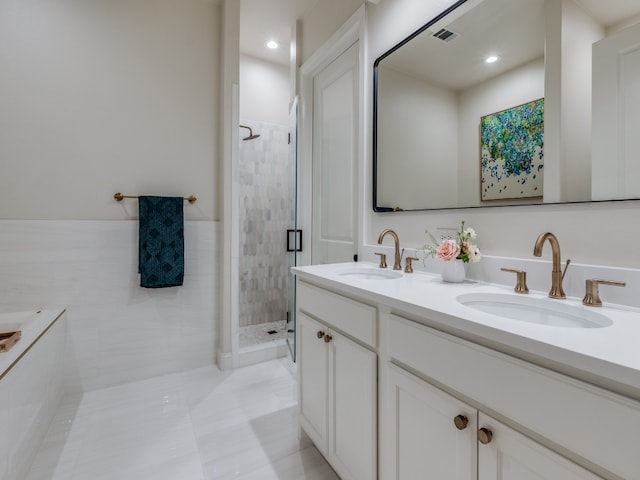 bathroom featuring a shower with door, tile walls, tile patterned floors, and vanity