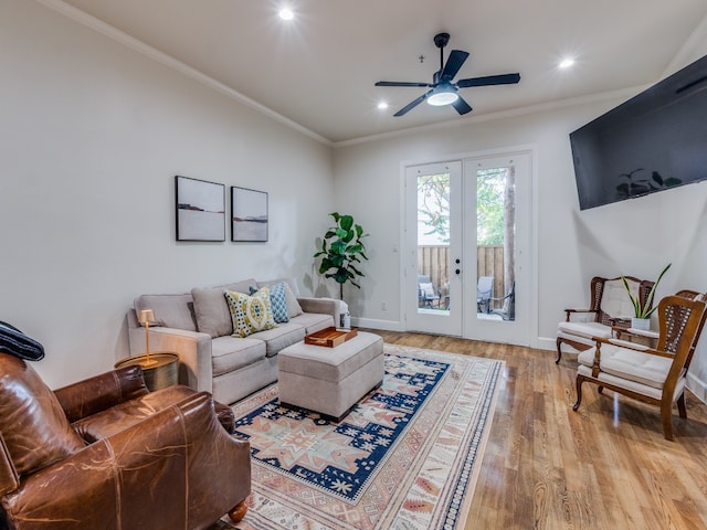 living room featuring french doors, ornamental molding, light wood-type flooring, and ceiling fan