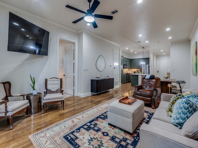 living room with ornamental molding and light hardwood / wood-style floors