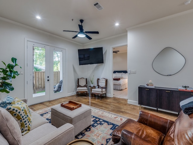 living room featuring french doors, crown molding, light hardwood / wood-style floors, and ceiling fan