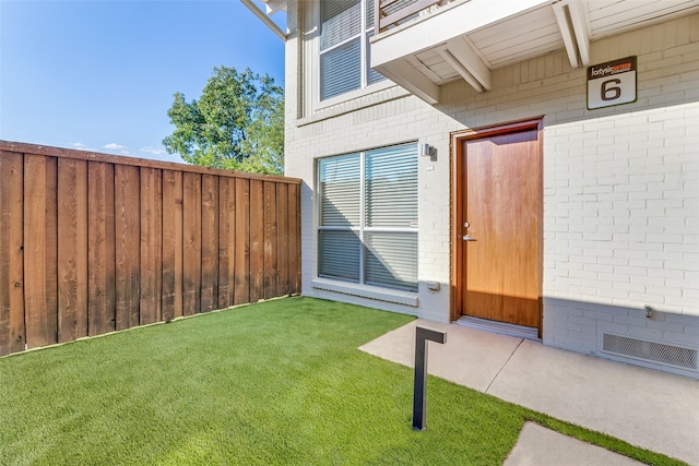 entrance to property featuring a lawn