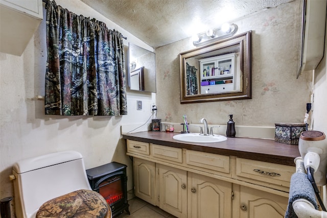 bathroom featuring vanity, a textured ceiling, toilet, and tile patterned floors