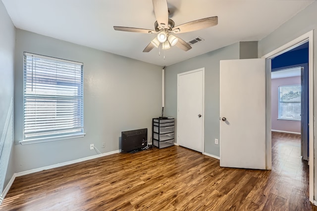 unfurnished bedroom featuring dark hardwood / wood-style flooring and ceiling fan