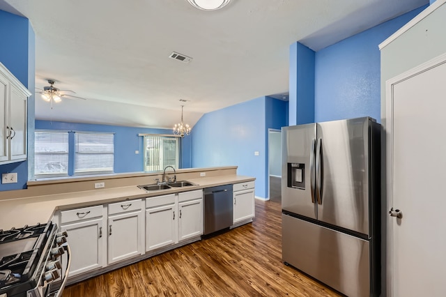 kitchen featuring stainless steel appliances, sink, decorative light fixtures, white cabinets, and dark hardwood / wood-style flooring