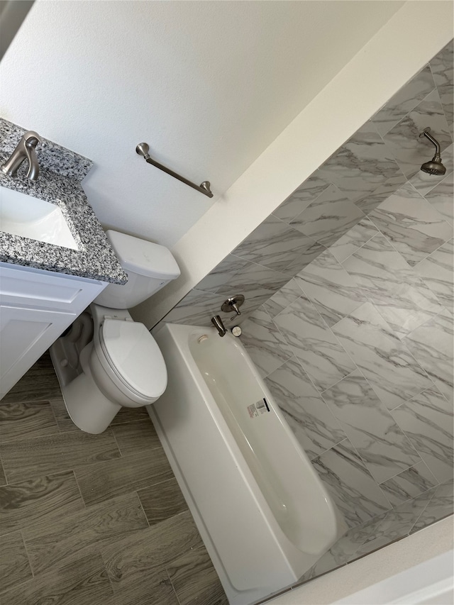 bathroom with vanity, a bathtub, and toilet