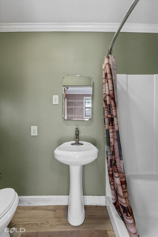 bathroom featuring toilet, crown molding, a shower with shower curtain, and hardwood / wood-style floors