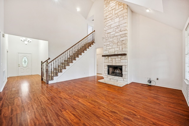 unfurnished living room featuring hardwood / wood-style floors, a fireplace, and high vaulted ceiling