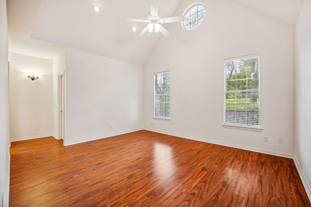 unfurnished room featuring plenty of natural light, high vaulted ceiling, and wood-type flooring