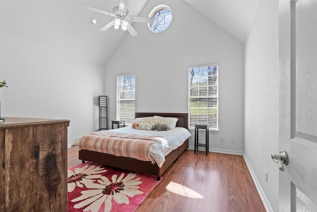 bedroom featuring multiple windows, ceiling fan, hardwood / wood-style floors, and high vaulted ceiling