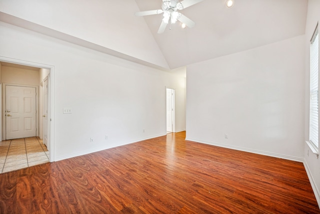 spare room featuring light wood-type flooring, high vaulted ceiling, and ceiling fan