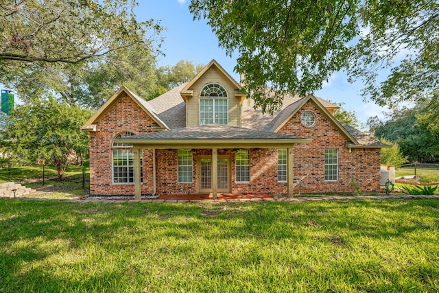 back of property with a lawn, brick siding, and roof with shingles
