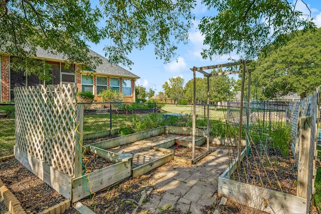 view of yard featuring fence and a vegetable garden