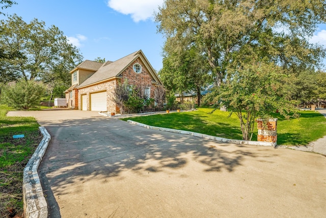 view of front of house featuring concrete driveway, brick siding, a front yard, and a garage