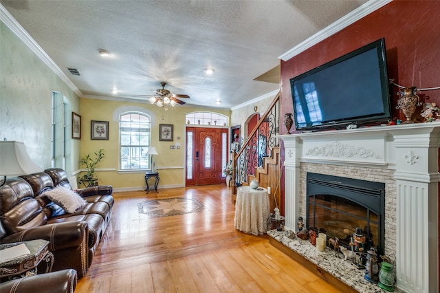 living room with crown molding, hardwood / wood-style flooring, a textured ceiling, and ceiling fan