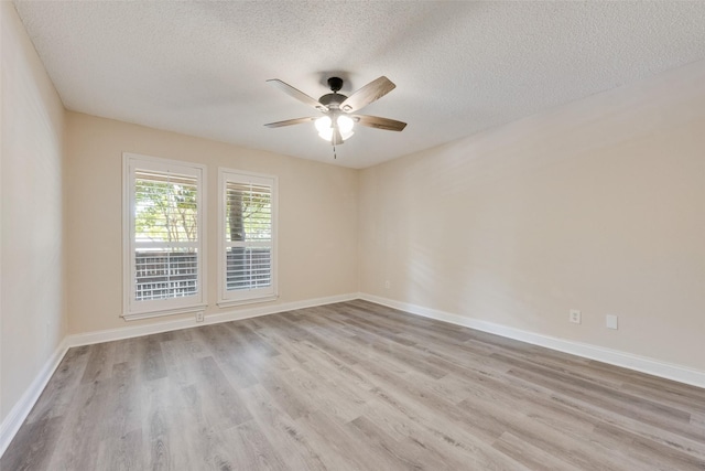 empty room with a textured ceiling, ceiling fan, and light hardwood / wood-style flooring