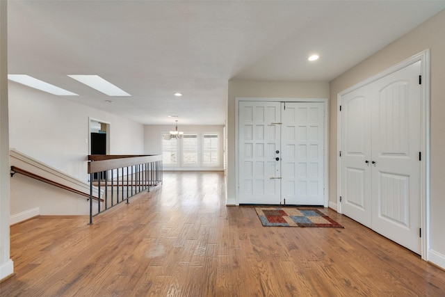 foyer entrance featuring light hardwood / wood-style flooring and a notable chandelier