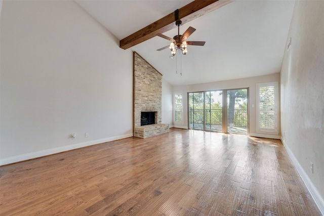 unfurnished living room featuring beamed ceiling, a fireplace, light hardwood / wood-style floors, ceiling fan, and high vaulted ceiling