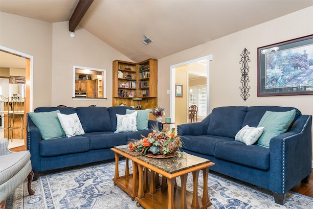 living room with hardwood / wood-style floors and vaulted ceiling with beams