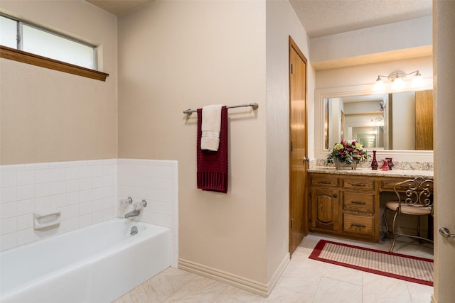 bathroom featuring a textured ceiling, vanity, a tub to relax in, and tile patterned floors