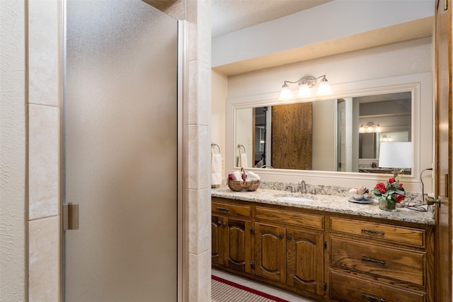 bathroom featuring vanity and an enclosed shower