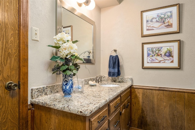 bathroom with wood walls and vanity