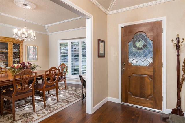 entrance foyer featuring dark hardwood / wood-style floors, an inviting chandelier, lofted ceiling, and crown molding