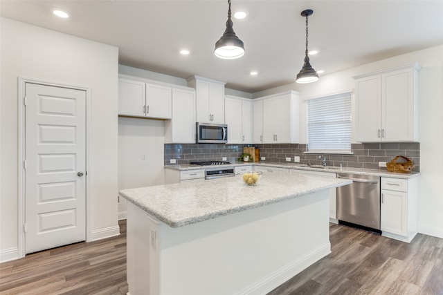 kitchen with a center island, appliances with stainless steel finishes, wood-type flooring, and white cabinets