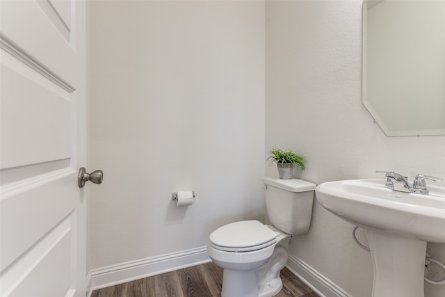 bathroom featuring toilet, hardwood / wood-style flooring, and sink