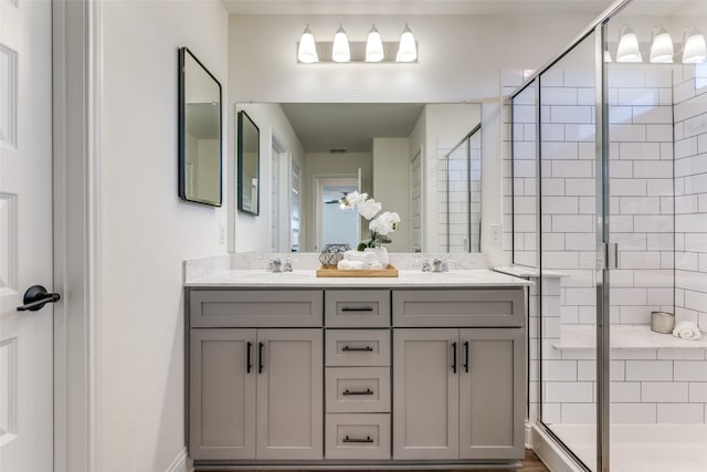 bathroom with a shower with door and vanity