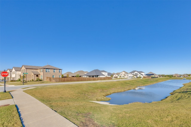 surrounding community featuring a lawn and a water view