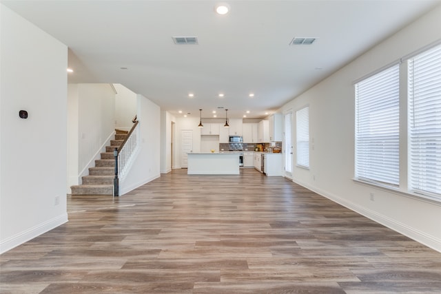 unfurnished living room featuring light hardwood / wood-style floors and a wealth of natural light