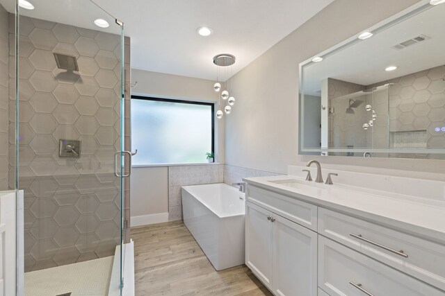 bathroom with wood-type flooring, vanity, and separate shower and tub