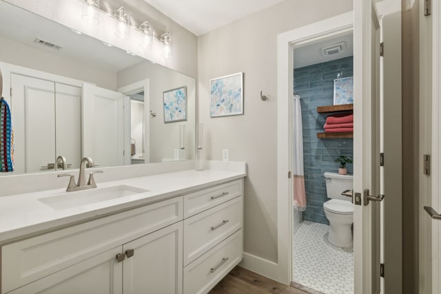 bathroom featuring toilet, walk in shower, and vanity